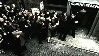 The Cavern Club is beseiged by a crowd of fans in the early days of Beatlemania in the UK.